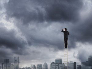 Corporate man climbing a ladder to nowhere