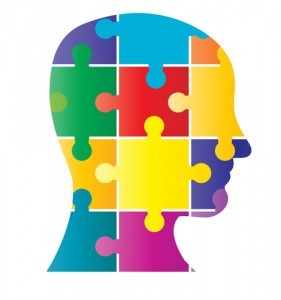 Silhouette image of a head that is made up of coloured puzzle pieces